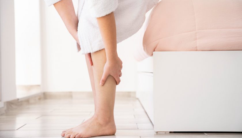 une femme se touchant les jambes
