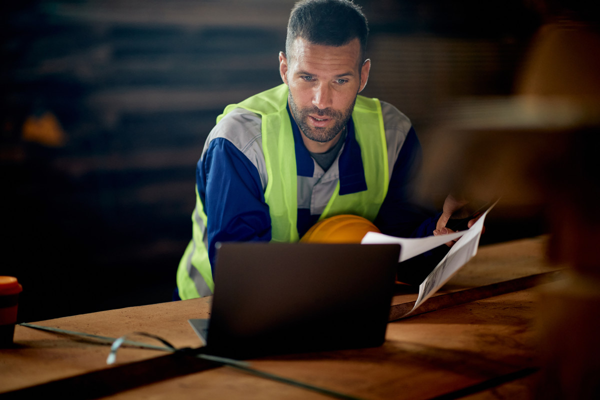 Un homme dans la construction regardant son ordinateur