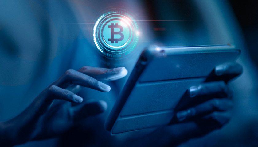 un homme achetant des cryptomonnaies sur sa tablette