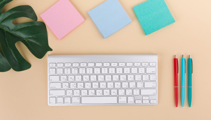 clavier d'ordinateur à coté de post-it et stylos