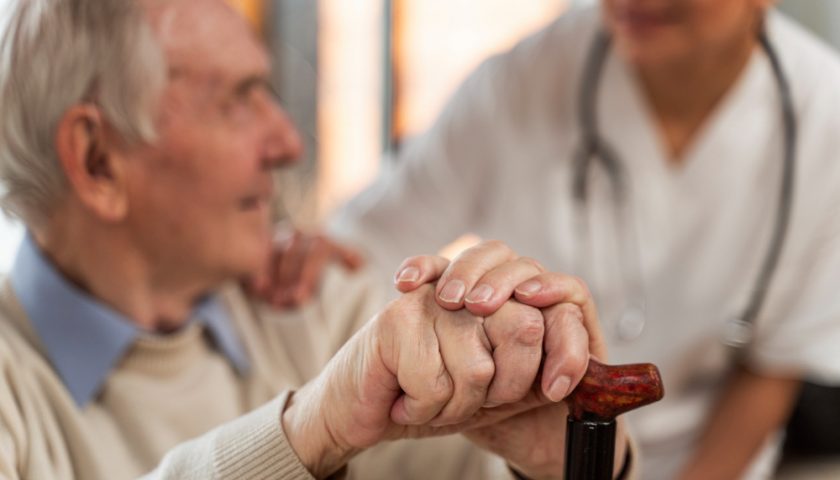 une personne âgée qui tient sa cane