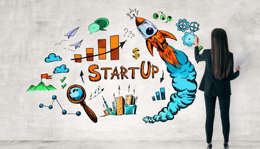 une femme fait un dessin représentant une start up sur un mur
