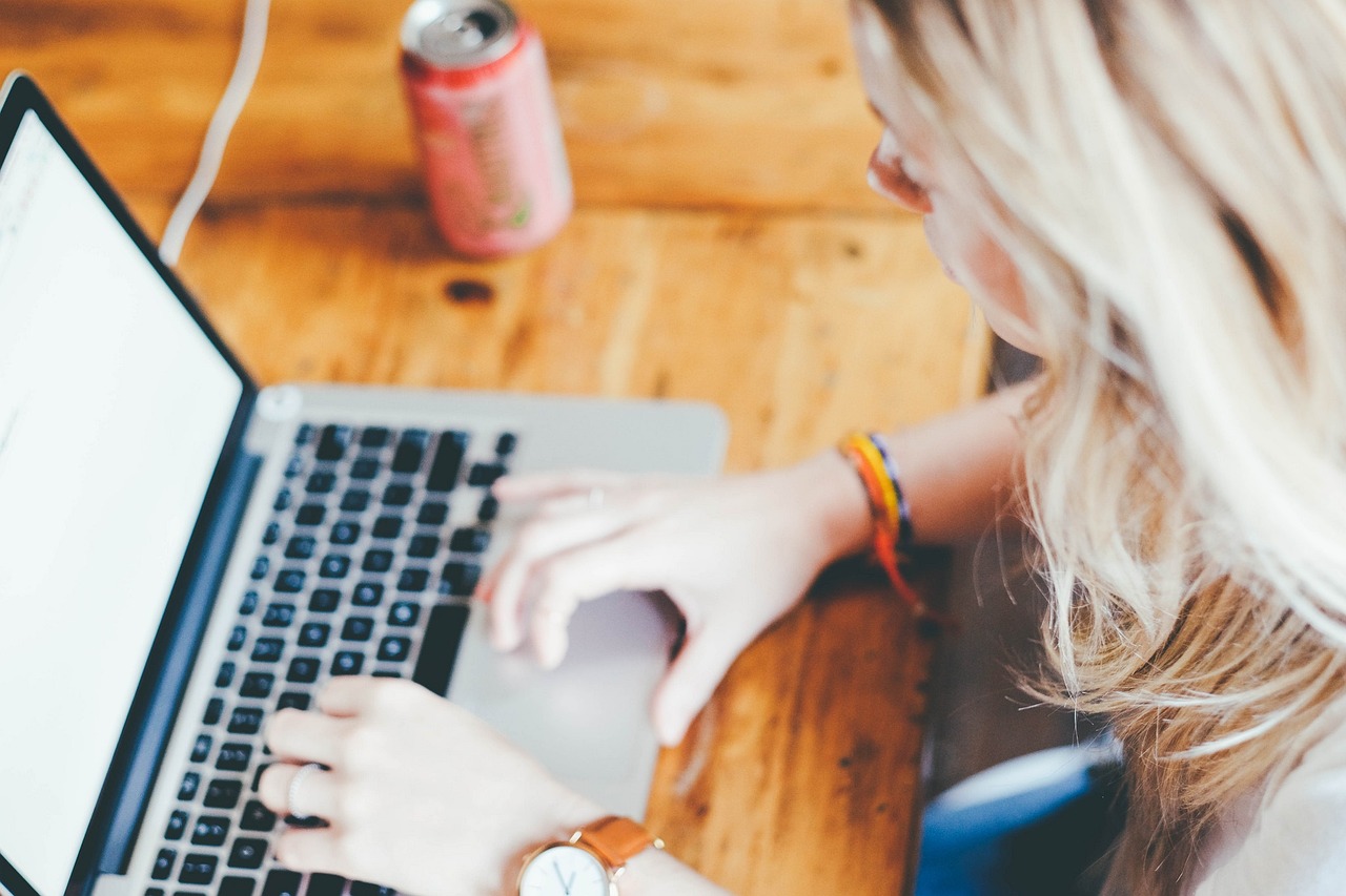 une femme blonde travaillant sur son ordinateur portable