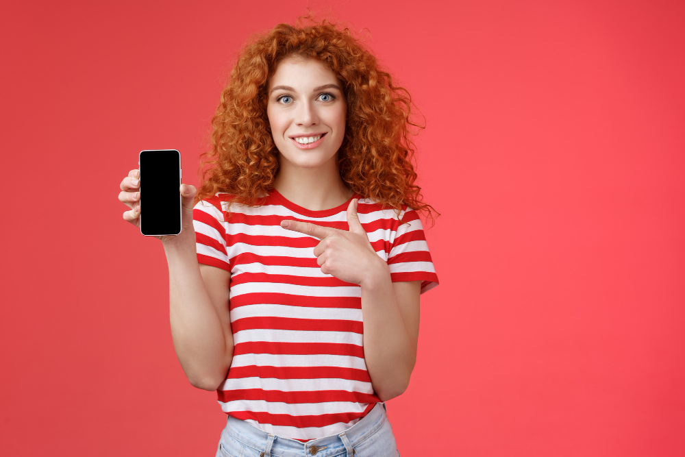 femme pointe son telephone du doigt