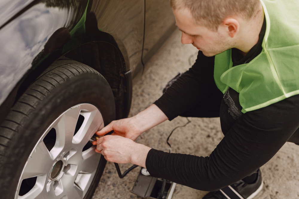 homme qui gonfle une roue de voiture