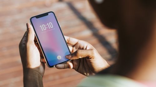 une femme tenant et regardant son iphone