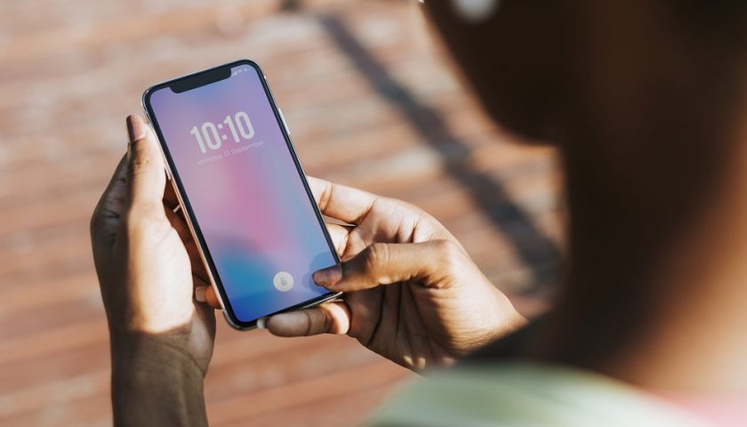 une femme tenant et regardant son iphone