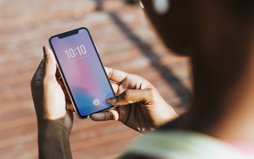 une femme tenant et regardant son iphone