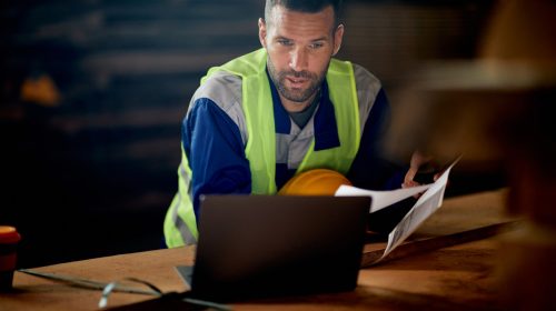 Un homme dans la construction regardant son ordinateur