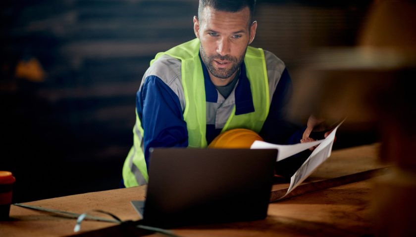 Un homme dans la construction regardant son ordinateur