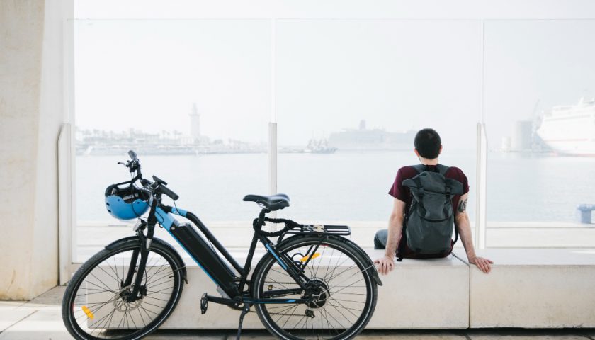 un homme assis à côté de son vélo électrique