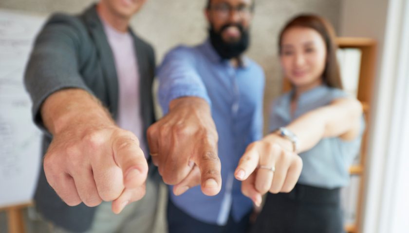 trois personnes pointant du doigt